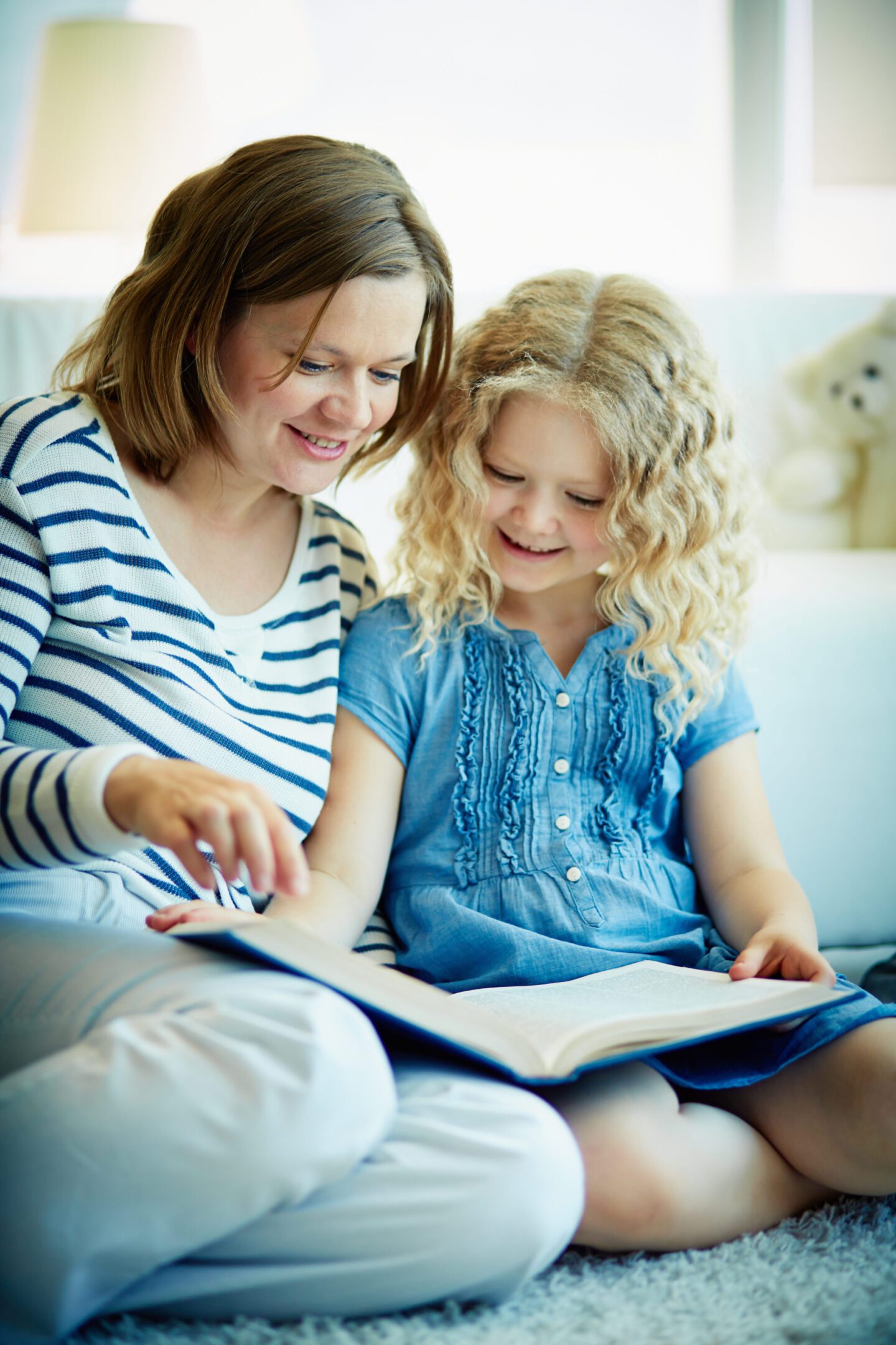 Mother and daughter reading a book together.