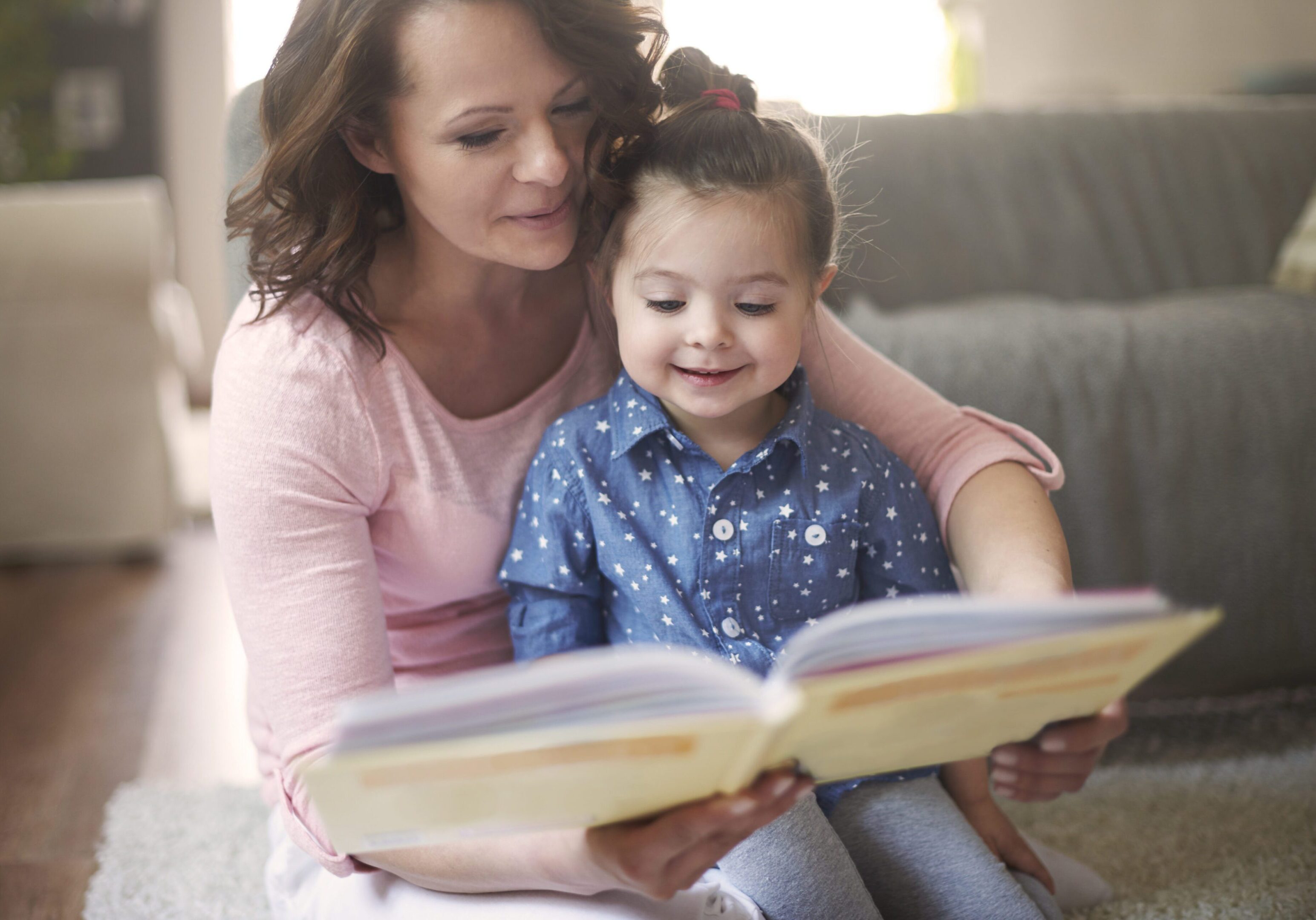 Mother and daughter reading a book together.